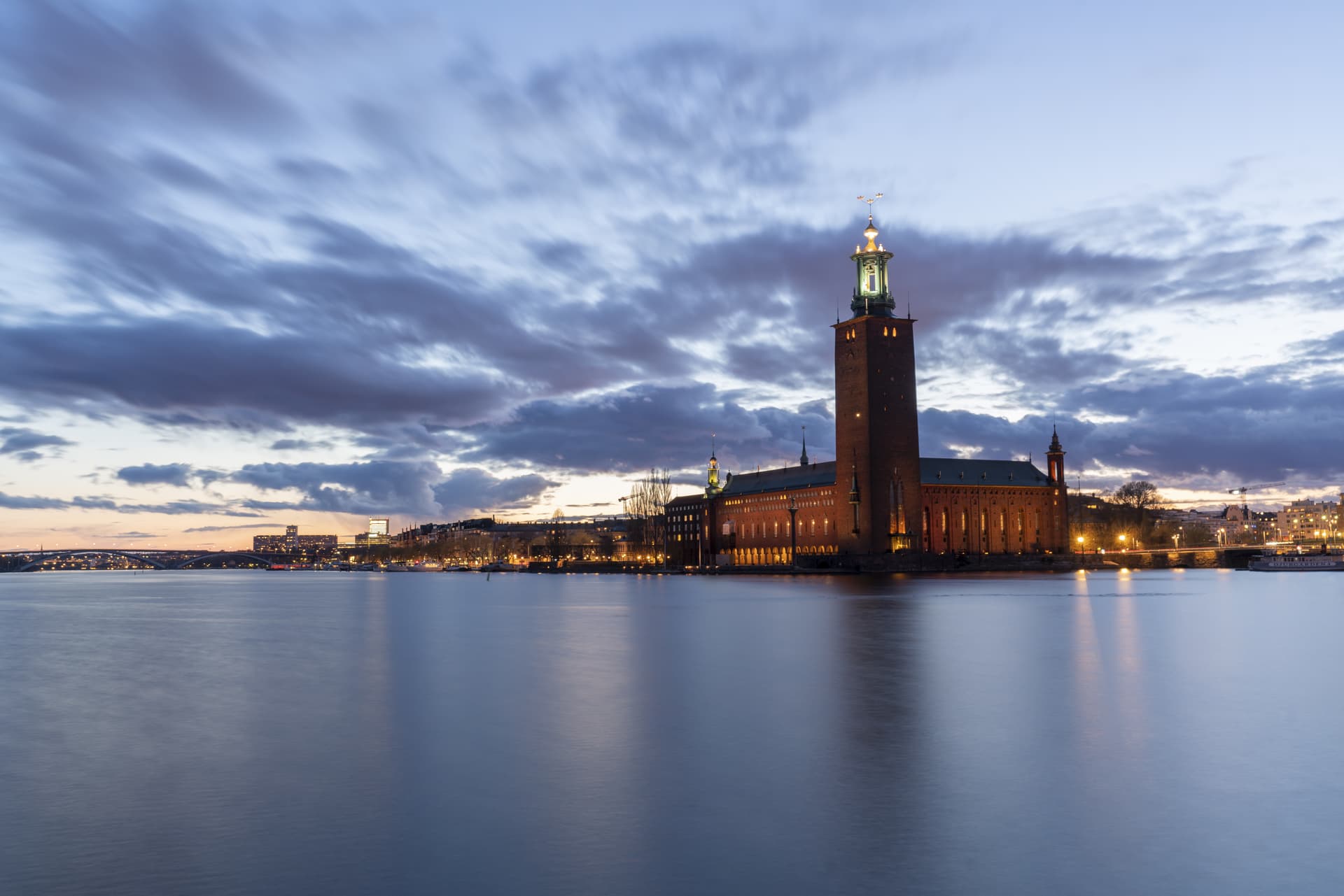 Stockholms stadshus i skymning sett över vattnet