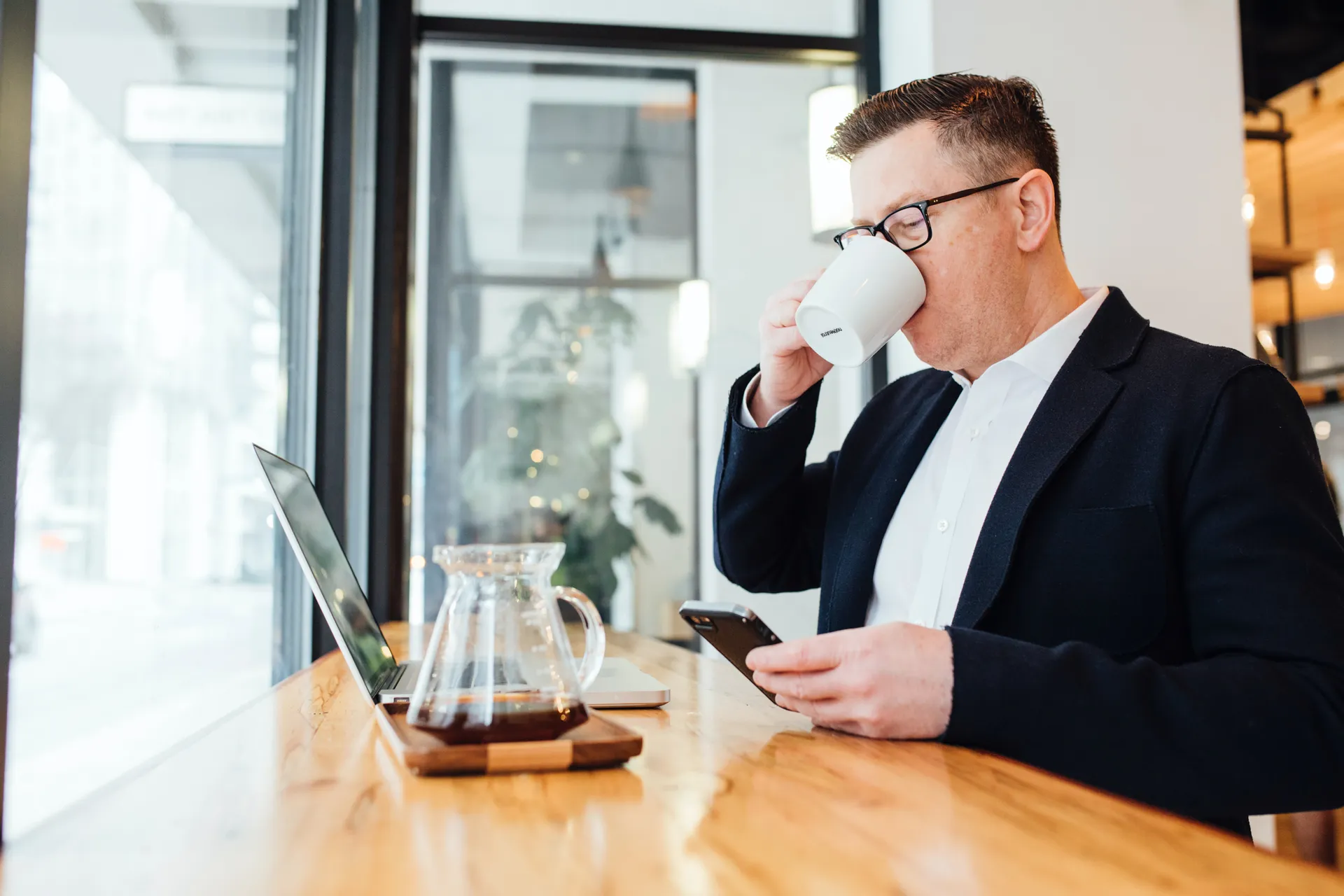 en man i kostym tar ett båtlån och dricker kaffe