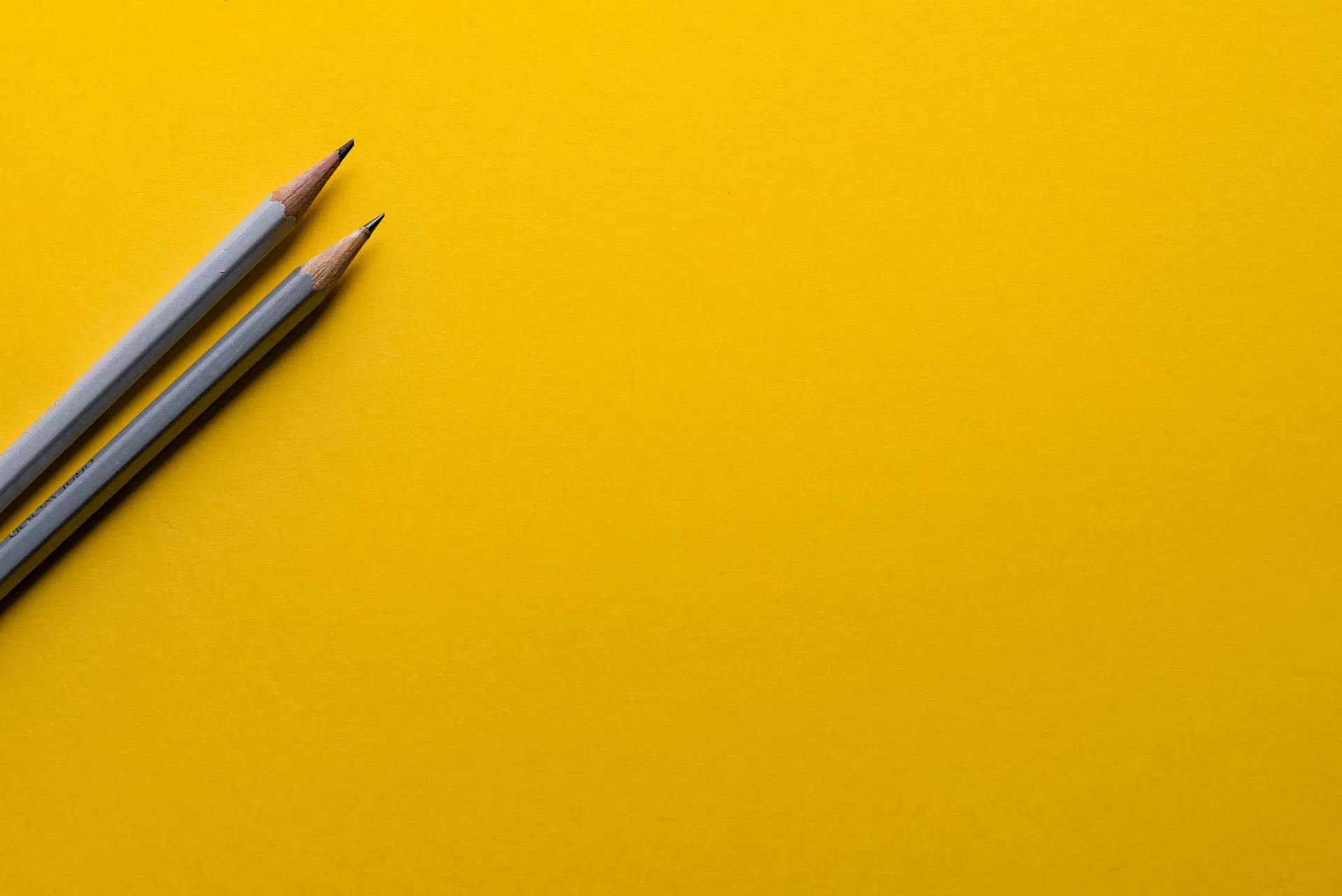 Två pennor på gul bakgrund som räknar avida ränta
