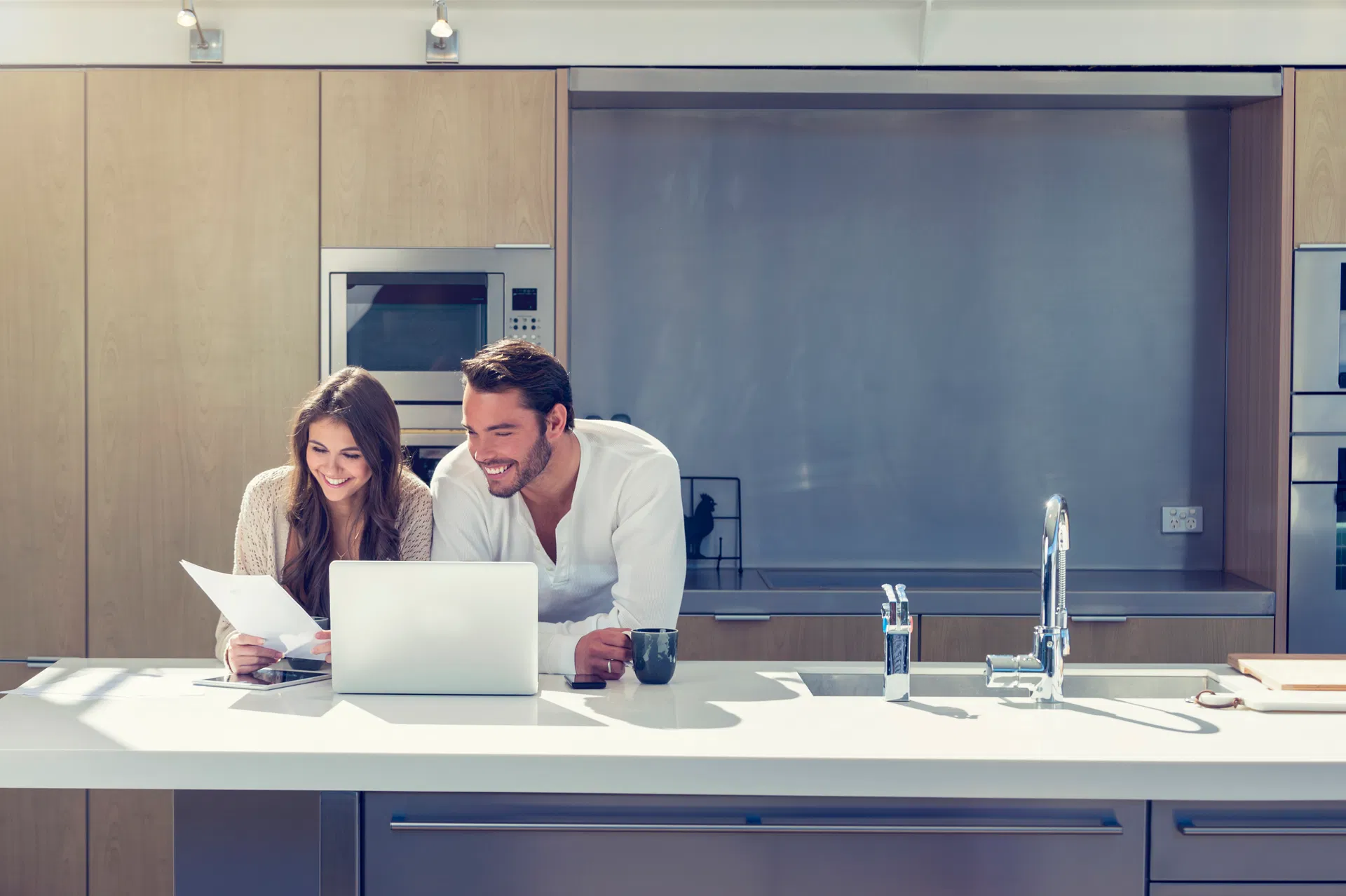 Ett par står i köket med en dator och tar lån hos Instabank