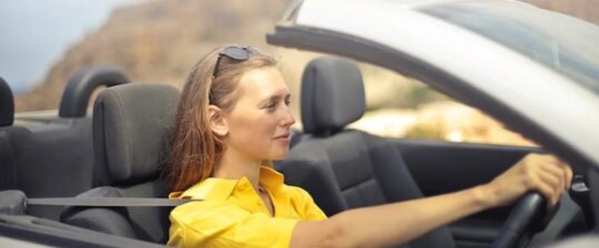 kvinna i gul tröja kör bil och pratar med wästgöta finans