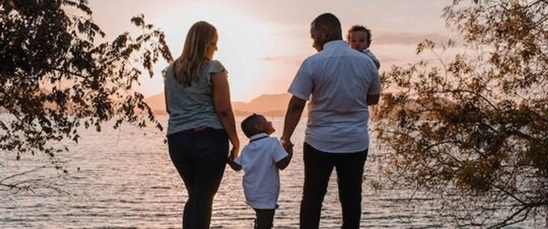 familj med tryggt billån besöker sjö vid solnedgång